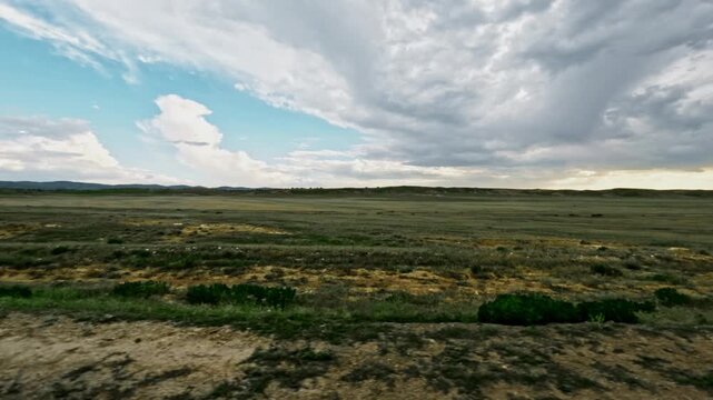 Off-road vehicle view of expansive landscape with clouds and greenery