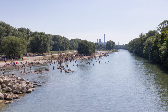 People cooling off in a river in the middle of a city on a hot day. Munich, Germany