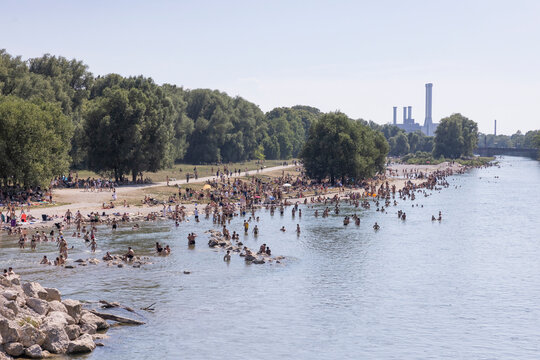 People cooling off in a river in the middle of a city on a hot day. Munich, Germany