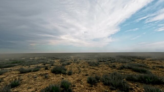 Off-road vehicle view of expansive landscape with clouds and vegetation