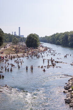 People cooling off in a river in the middle of a city on a hot day. Munich, Germany