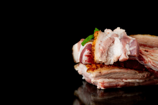 Traditional pork lard with fresh basil on black reflective background