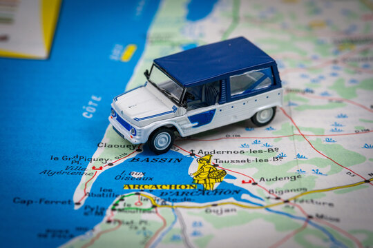 toy Citro&euml;n Mehari van positioned near "Arcachon" and "Bassin d'Arcachon" on a road map, with a decorative illustration of a local figure and coastal place names visible.