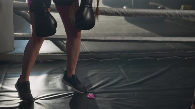Young Caucasian female boxers sparring in ring, with one athlete spitting out mouthguard after intense hit. Footage ideal for sports motivation campaigns and fitness brand advertisements