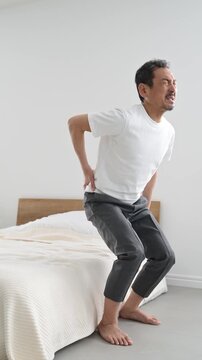 腰を押さえて痛がる50代の日本人男性