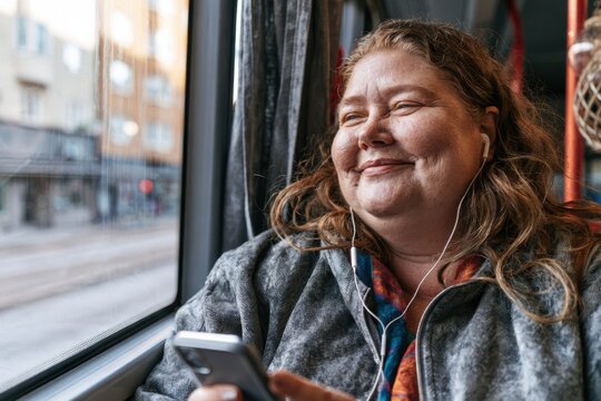 Smiling Woman Using Cell Phone While Traveling by Bus