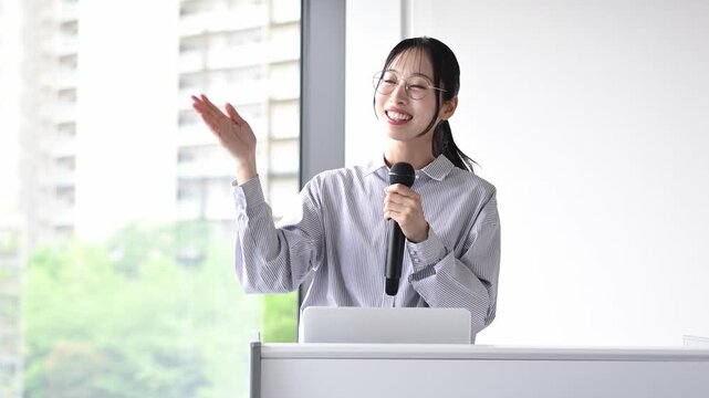 プレゼンテーションをする30代日本人女性