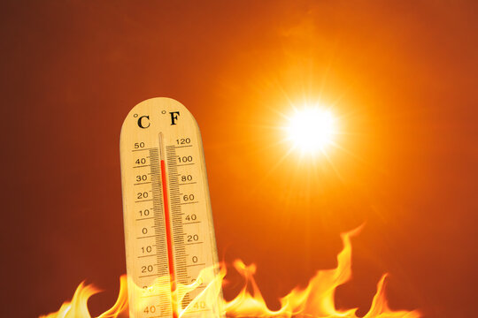 Global boiling concept featuring a thermometer, blazing sun, and flames representing extreme heat and climate change.
