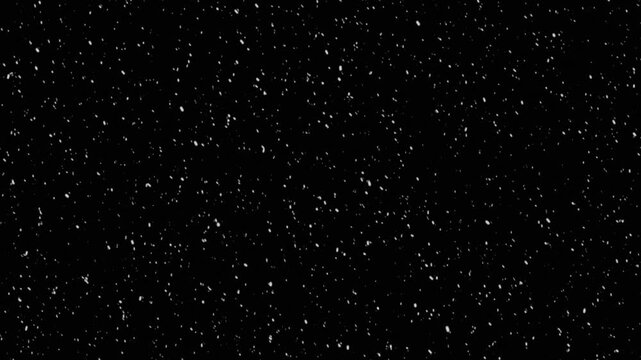 Scattered white particles floating against solid deep black background. Dust effect or snowy weather simulation.