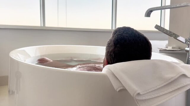  Man Relaxing in a Luxury Freestanding Bathtu