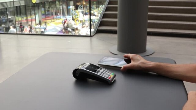 Person using a smartphone for contactless payment on a pos terminal, illustrating nfc technology for cashless transactions, secure mobile banking, and modern commerce