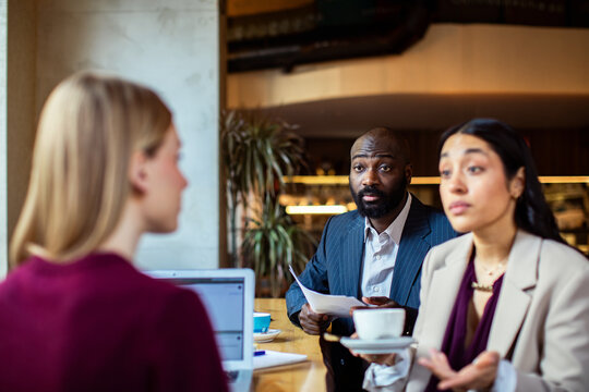Managers interviewing candidate in modern coffee shop