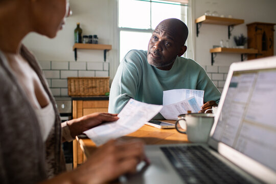 Couple reviewing household bills at kitchen table