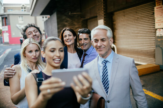 Business colleagues taking a group selfie on city street