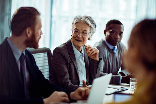 Senior businesswoman leading team discussion in modern office