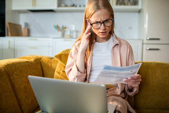 Concerned woman reviewing household bills at home