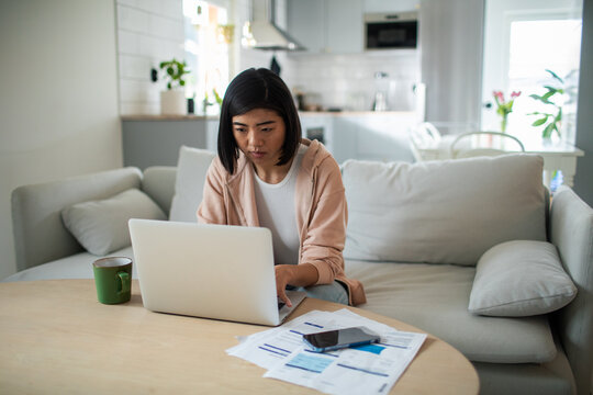 Woman paying household bills online at home