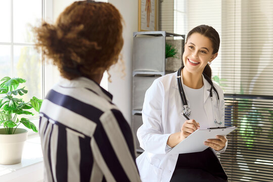 Doctor patient consultation in clinic for healthcare. A woman meets a medical professional during an appointment for discussion of symptoms and treatment options. Clear concept of trusted care.