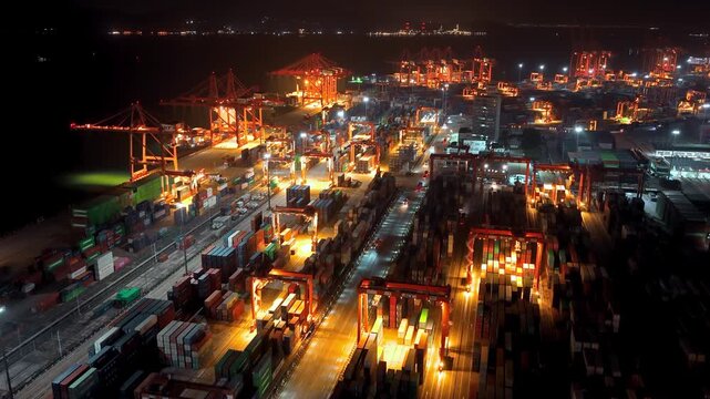 Unloading large cargo containers seaport. Loading freight sea port. Top aerial drone view. Lot big boxes rows, ship delivery ocean harbor. Shipping night. Goods export import. Industrial Marine dock.