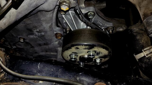 Close-up of a newly installed car engine water pump and pulley assembly.