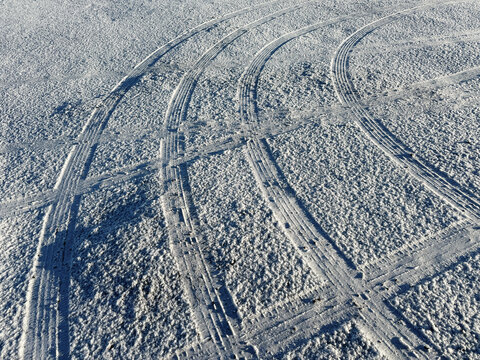 Curved Tyre Tracks Across Frost Covered Ground