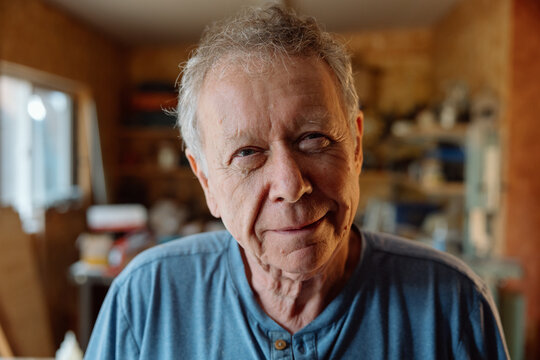 Candid portrait of a smiling senior man in his workshop