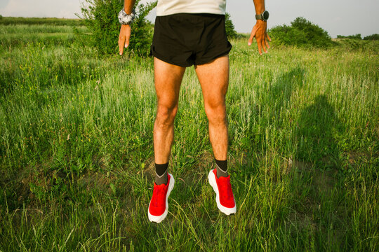 A trail runner is doing a vigorous warm-up in a field before practice
