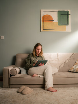 Woman working on digital tablet at home 