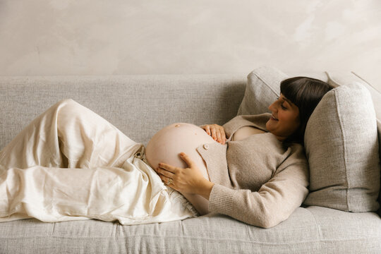 Pregnant Woman Resting on Sofa During Late Pregnancy