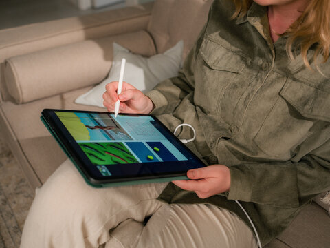 Person Creates Digital Art Using Tablet in Cozy Living Room