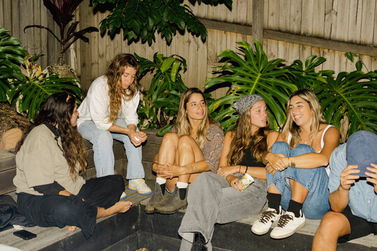 UGC Girls friends chatting around fire pit at backyard night party