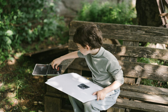 Creative little boy exploring art outside alone