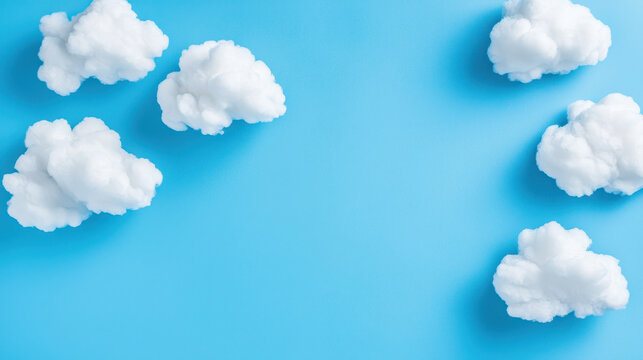 Fluffy white clouds scattered against bright blue background create serene and cheerful atmosphere