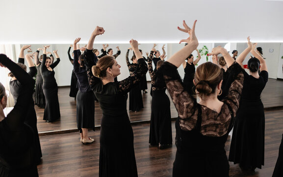 Women learning flamenco dance movements in studio class
