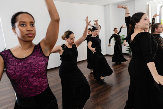 Women learning flamenco dancing in studio class