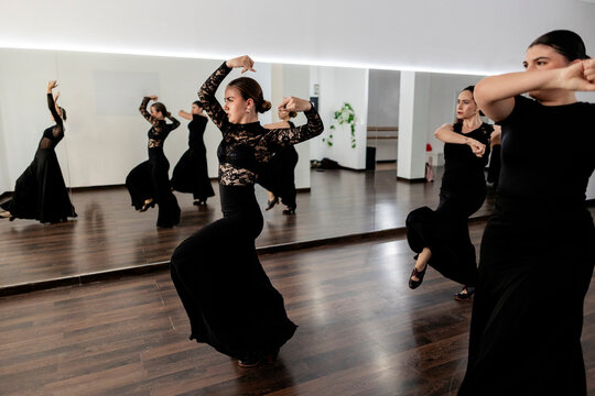 Group of women practicing traditional flamenco dance in studio