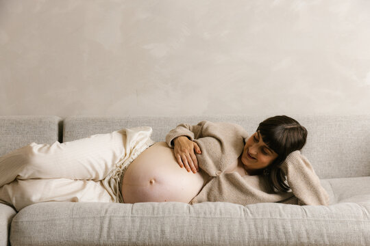 Pregnant Woman Resting on Sofa During Late Pregnancy
