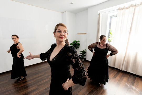 Women performing traditional flamenco dance in studio