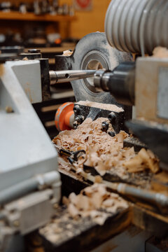 Wood lathe turning with wood shavings in a workshop