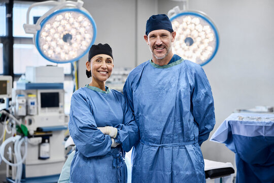 Two smiling surgeons stand together