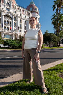 Confident Happy Senior Woman In Front Of Hotel Negresco In Nice