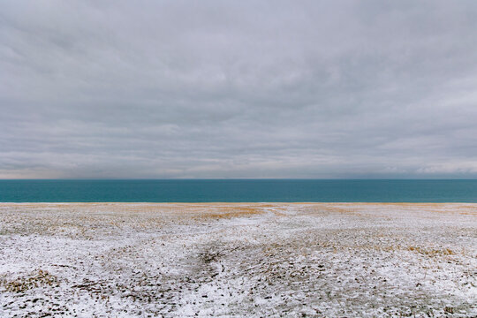 Minimalist landscape: Sky, lake, and grassland.