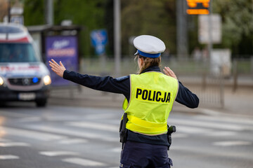 Policjantka ruchu drogowego kieruje ruchem drogowym na ulicy.  © FotoDax