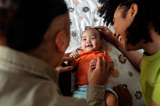 Diverse family parents smiling with happy infant baby