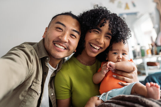 Diverse happy family parents and baby taking a selfie