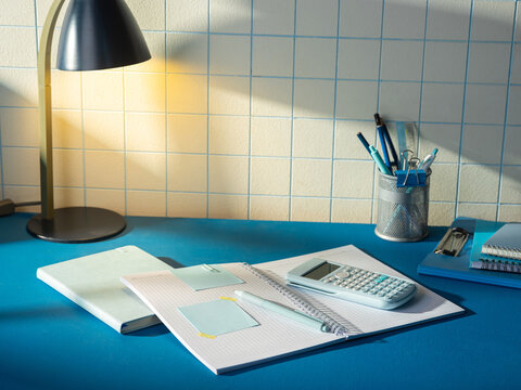 Desk setup with study supplies and a lamp casting warm light