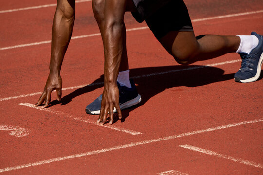 Runner Prepares to Start a Race on a Red Track Surface