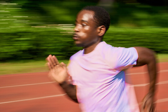 Boy Runs Fast on Track During Sunny Day at School