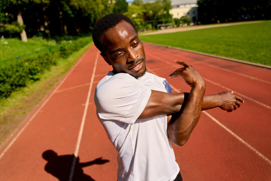 Runner Stretches on the Track in a Training Session in the Afternoon