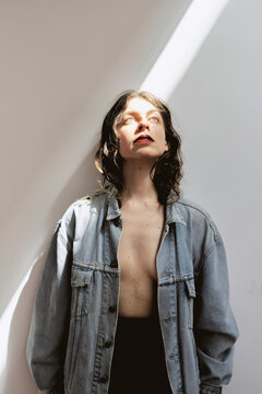 Bright light shines on a woman in a studio setting